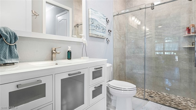 bathroom with an enclosed shower, vanity, tile flooring, and toilet