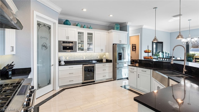 kitchen with pendant lighting, stainless steel appliances, beverage cooler, white cabinets, and sink