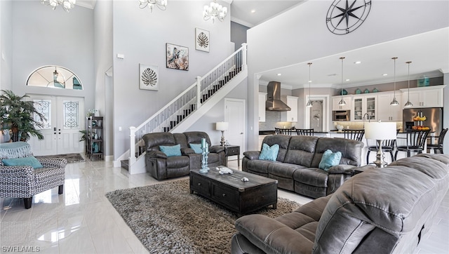 living room featuring an inviting chandelier, ornamental molding, light tile floors, and a high ceiling