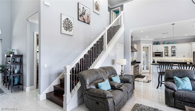 tiled living room with crown molding and a towering ceiling