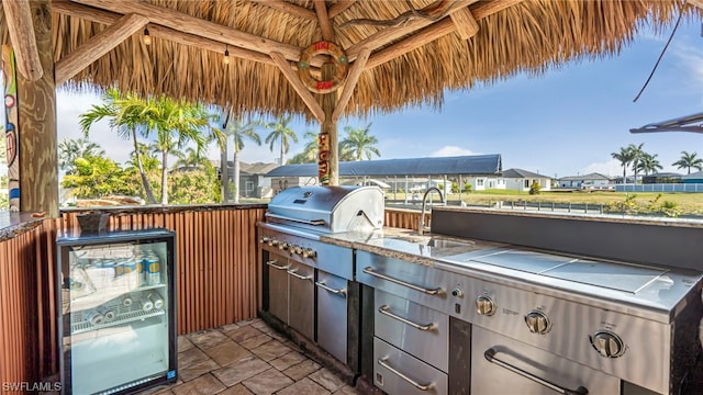 view of patio with an outdoor kitchen, grilling area, and sink