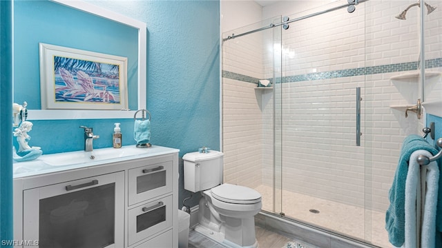 bathroom featuring toilet, vanity, a shower with shower door, and hardwood / wood-style floors