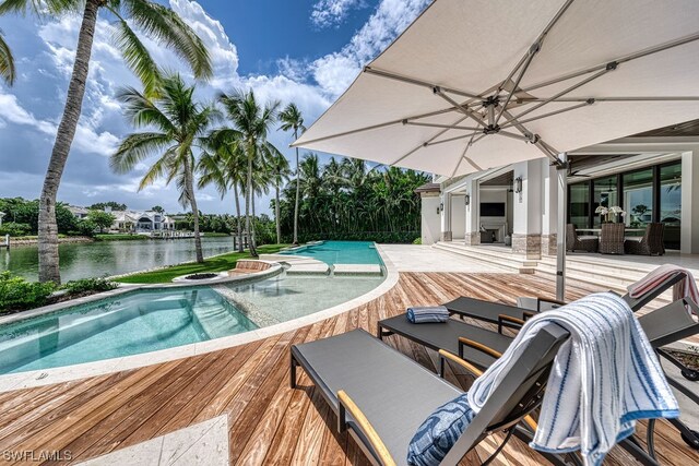 view of pool featuring a jacuzzi, a patio, and a water view