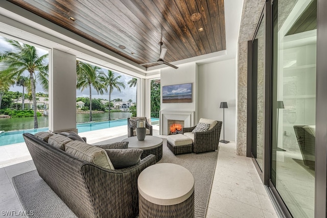 exterior space featuring a tray ceiling, ceiling fan, a pool, a water view, and wooden ceiling