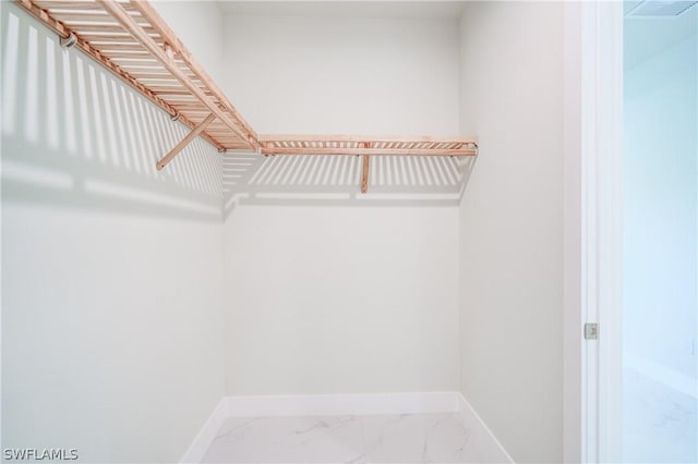 walk in closet with marble finish floor and visible vents