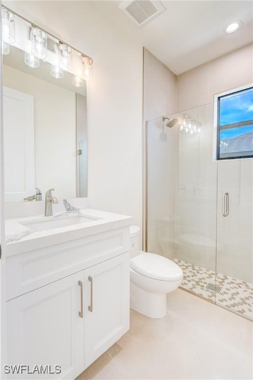 bathroom with an enclosed shower, vanity, and toilet