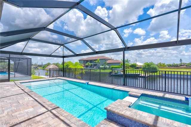 view of swimming pool with an in ground hot tub, a water view, a patio area, and glass enclosure