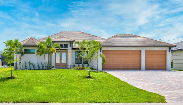 view of front of house featuring a garage, a front yard, and french doors