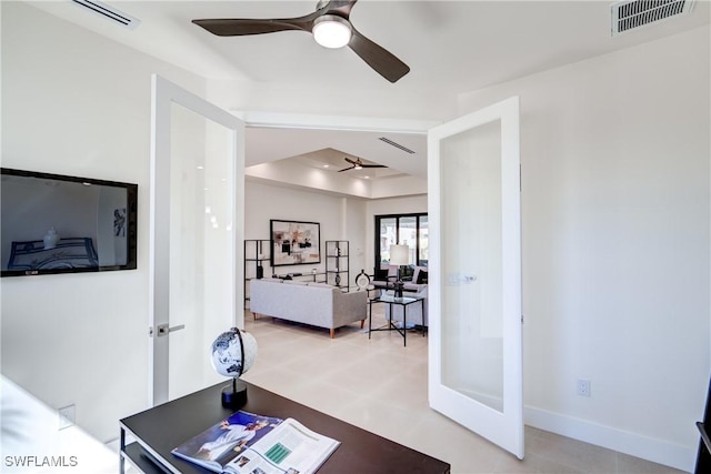 office area featuring a raised ceiling, visible vents, and ceiling fan