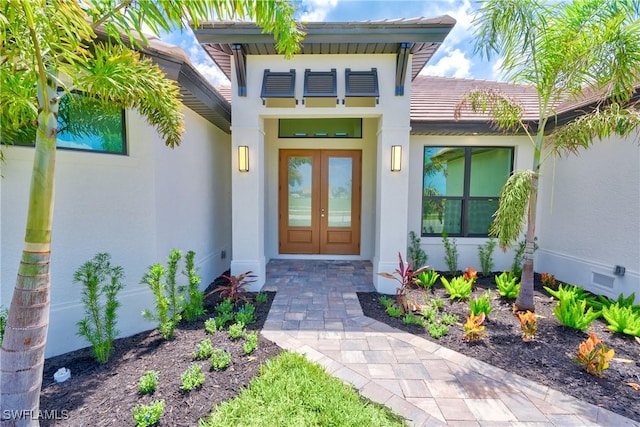 view of exterior entry with crawl space, stucco siding, and french doors