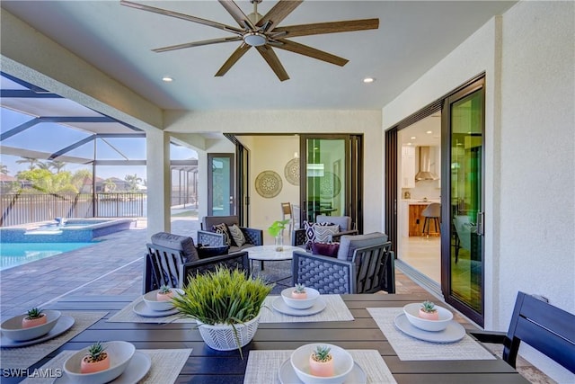 view of patio featuring a ceiling fan, an outdoor hangout area, a lanai, fence, and a pool with connected hot tub