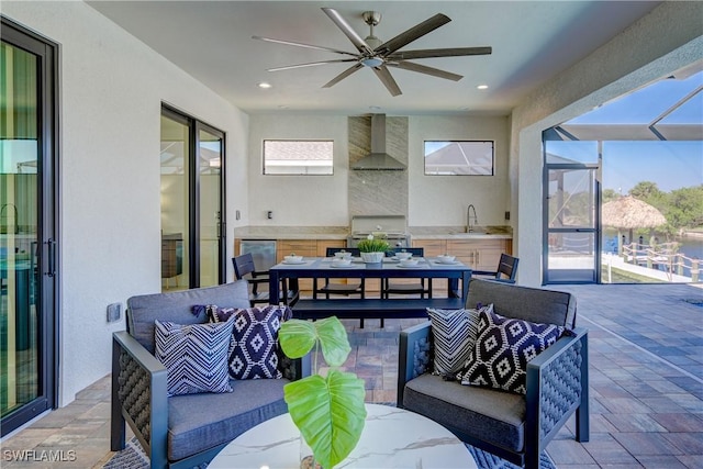 view of patio / terrace with a ceiling fan, area for grilling, glass enclosure, an outdoor living space, and a sink