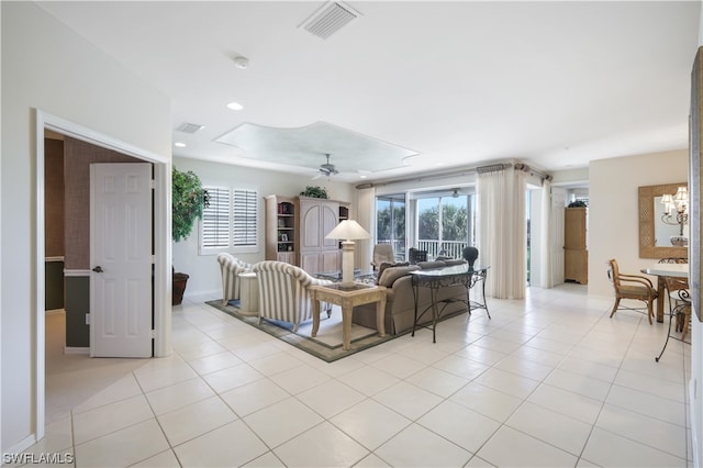 living room featuring light tile patterned floors and ceiling fan with notable chandelier