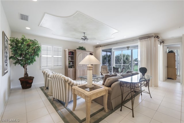 living room featuring ceiling fan, light tile patterned flooring, and a wealth of natural light