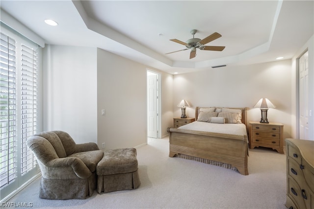 carpeted bedroom with access to exterior, a raised ceiling, and ceiling fan