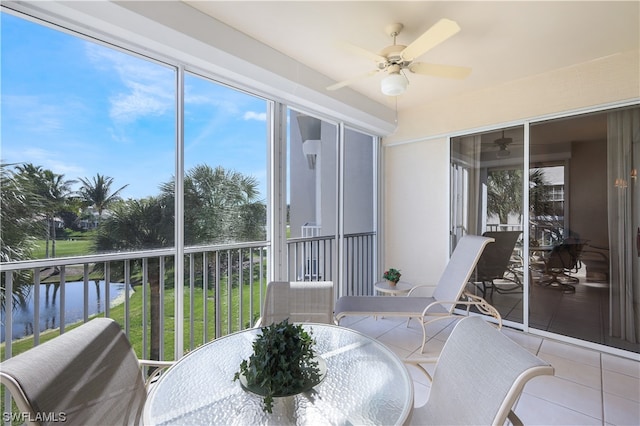 sunroom featuring a water view, plenty of natural light, and ceiling fan