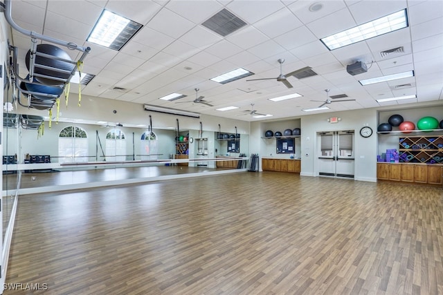 workout room with a drop ceiling and wood-type flooring