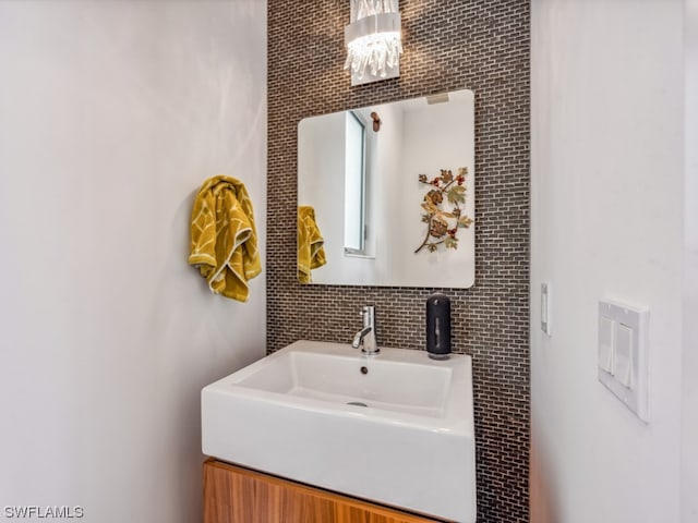 bathroom with sink and a notable chandelier