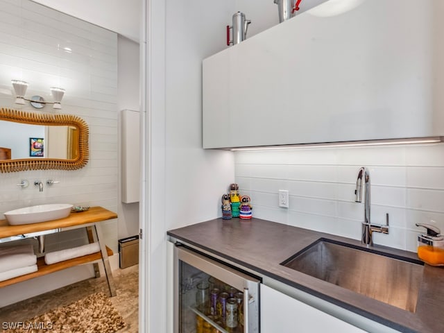 kitchen with white cabinetry, wine cooler, and sink