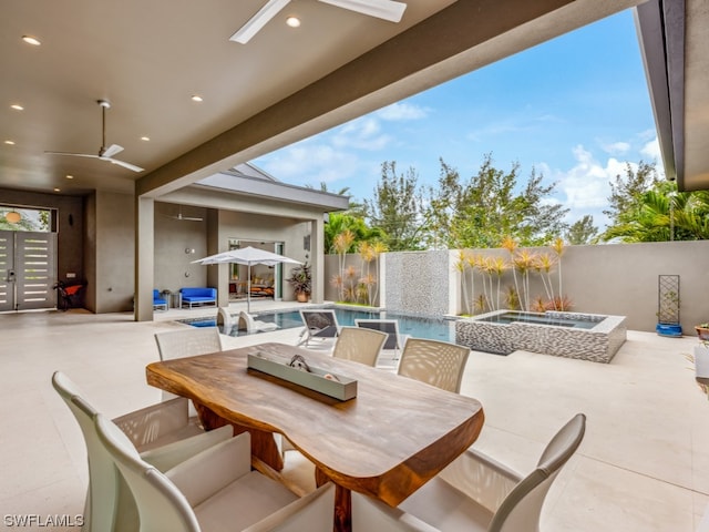 view of patio / terrace featuring ceiling fan and a swimming pool with hot tub