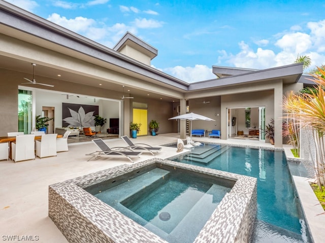 rear view of property featuring a patio, ceiling fan, and a pool with hot tub