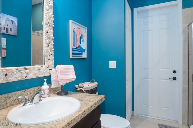 bathroom featuring a shower with door, vanity, and toilet