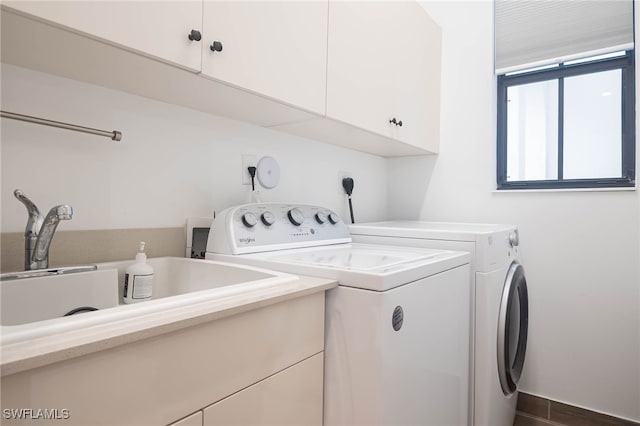 clothes washing area featuring cabinets and washer and clothes dryer