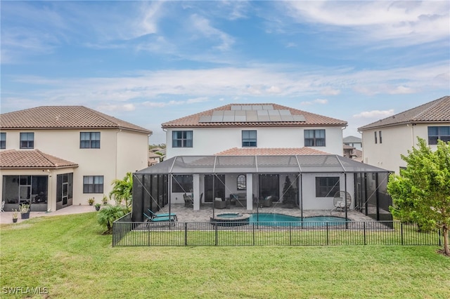 back of property with solar panels, a lanai, a yard, a fenced in pool, and a patio area