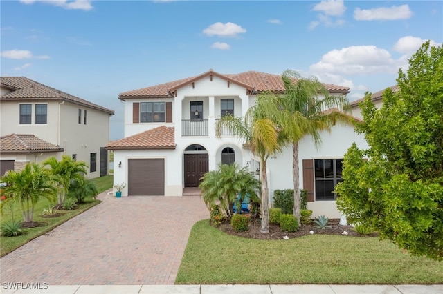 mediterranean / spanish house featuring a balcony and a front yard