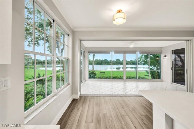 unfurnished sunroom with a water view and plenty of natural light