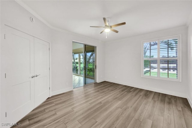 unfurnished bedroom featuring crown molding, light wood-type flooring, baseboards, and access to exterior