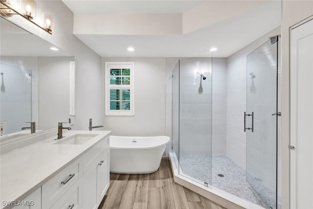 full bath featuring a stall shower, vanity, and wood finished floors