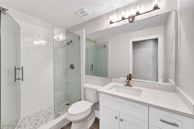 full bathroom featuring toilet, a stall shower, visible vents, and vanity