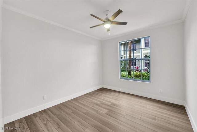 empty room with baseboards, wood finished floors, and ornamental molding