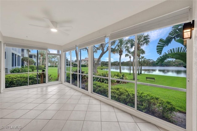 unfurnished sunroom featuring a water view and ceiling fan