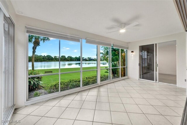 unfurnished sunroom featuring a water view and ceiling fan