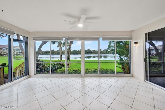 unfurnished sunroom with ceiling fan and a water view