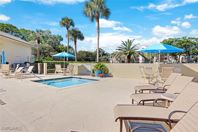 view of pool featuring a patio, a hot tub, and fence