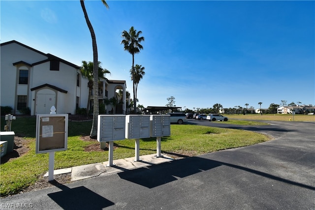 exterior space featuring a mail area and a lawn