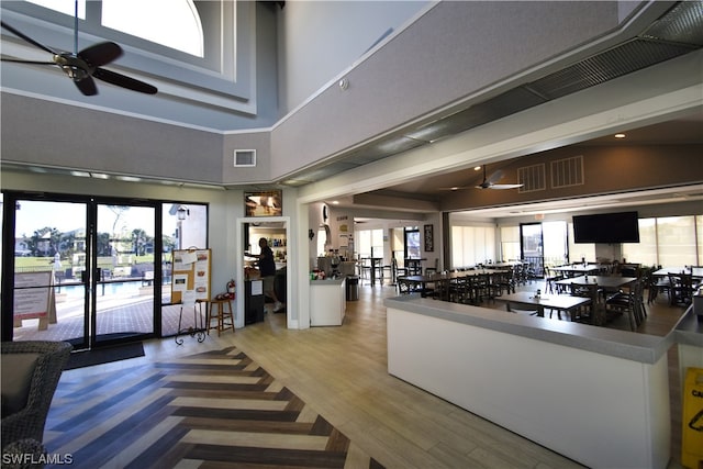 kitchen featuring ceiling fan, a towering ceiling, and white cabinets