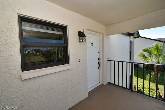 view of exterior entry featuring a balcony