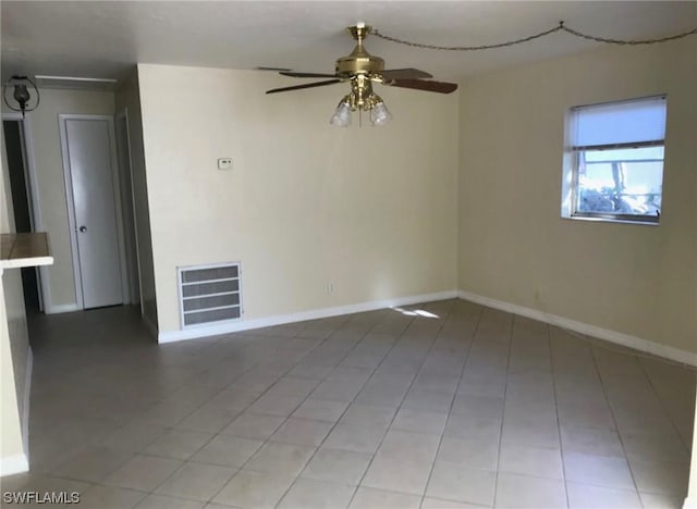 spare room featuring tile floors and ceiling fan