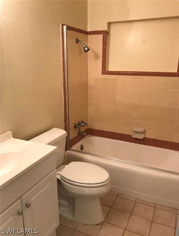 full bathroom featuring toilet, tile floors, tiled shower / bath combo, and vanity