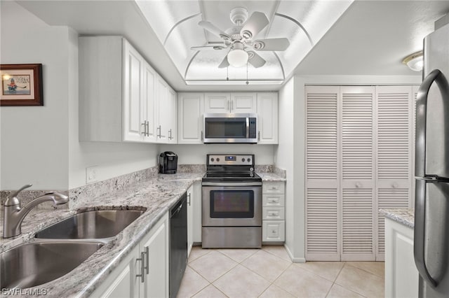 kitchen with white cabinets, appliances with stainless steel finishes, light tile patterned flooring, and sink