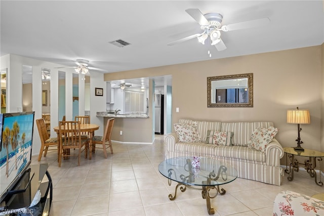 tiled living room featuring ceiling fan and sink