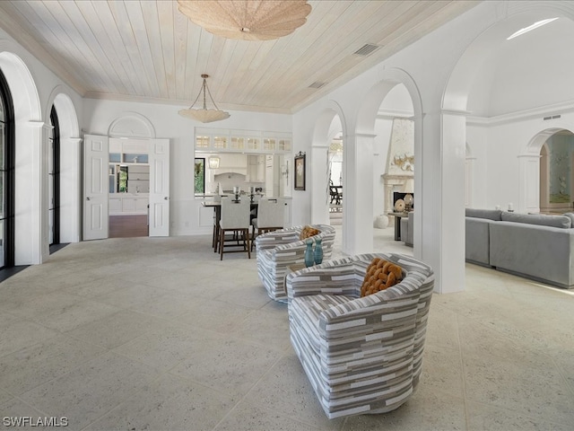 living room featuring wood ceiling, crown molding, and a towering ceiling