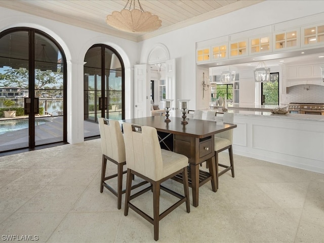 dining space featuring french doors and crown molding