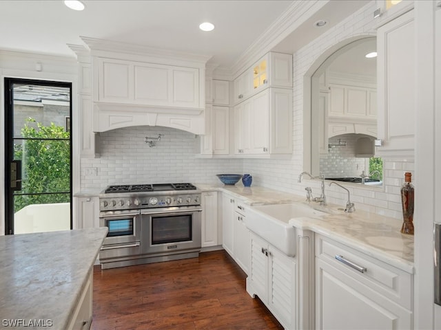 kitchen featuring double oven range, dark wood-type flooring, tasteful backsplash, light stone counters, and white cabinetry