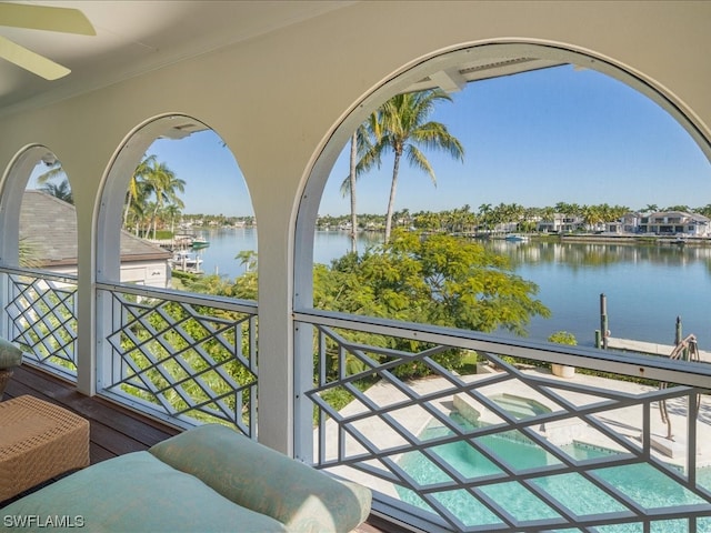 balcony featuring an in ground hot tub and a water view