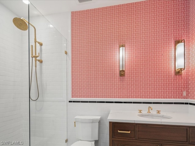 bathroom featuring toilet, tile walls, and sink